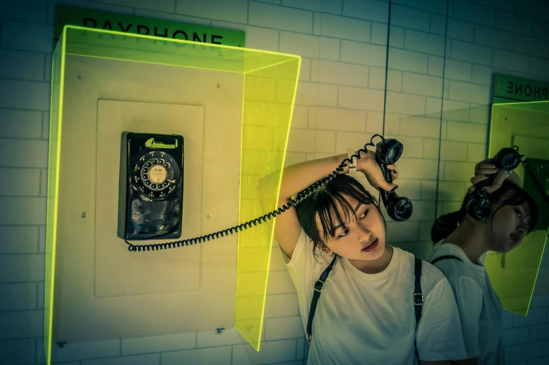 a woman holding a telephone in front of a mirror, inspired by Elsa Bleda, pexels contest winner, interactive art, neon tokyo, floating headsets, yellow, stood in a cell