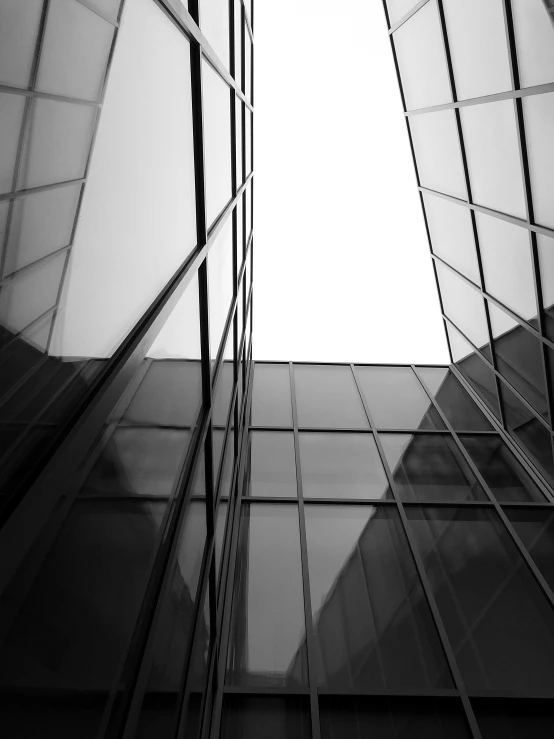 a black and white photo of a tall building, unsplash, minimalism, full of glass. cgsociety, square, worm\'s eye view, made of glass