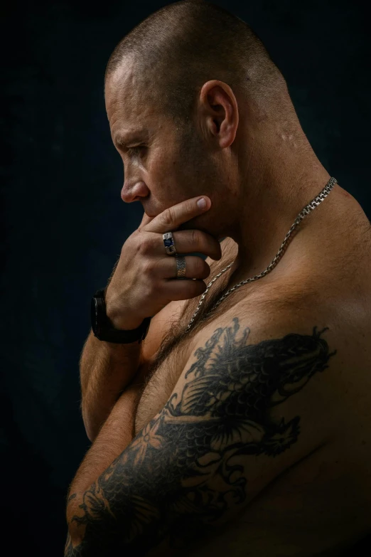 a man with a tattoo on his chest, inspired by Brian 'Chippy' Dugan, trending on pexels, hyperrealism, crouching, vin diesel, photography of bill brauer, pondering