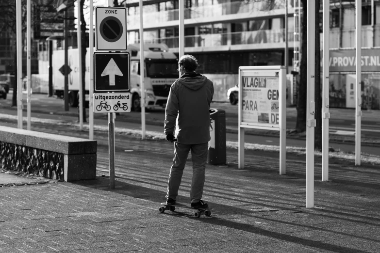 a black and white photo of a man on a skateboard, a black and white photo, by Matija Jama, unsplash, street signs, amsterdam, bus stop, one man is blond