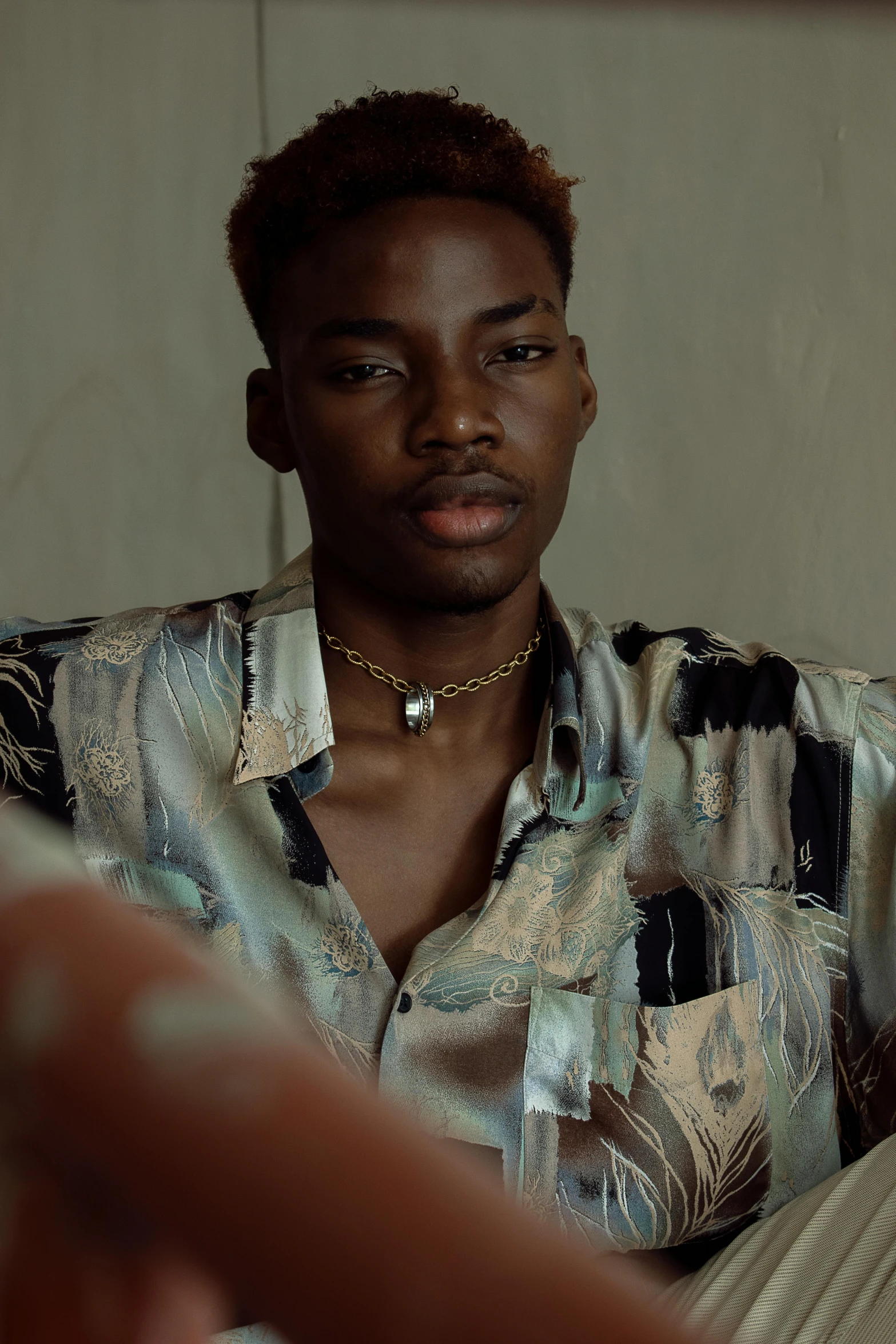 a man sitting on top of a couch next to a woman, an album cover, inspired by Xanthus Russell Smith, trending on pexels, photorealism, photo of a hand jewellery model, wearing a linen shirt, playboi carti portrait, serious look