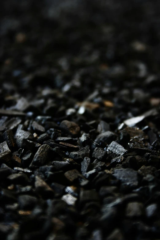 a close up of a pile of gravel, an album cover, unsplash, carbon fibers, black smoke, high quality photo, bark