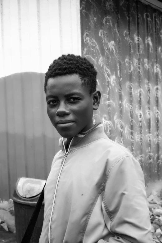 a black and white photo of a young boy, by Ottó Baditz, afrofuturism, aged 13, adebanji alade, boy has short black hair, photographed in film