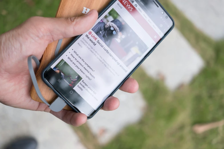 a close up of a person holding a cell phone, a picture, readability, thumbnail, in 2 0 1 8, news archive