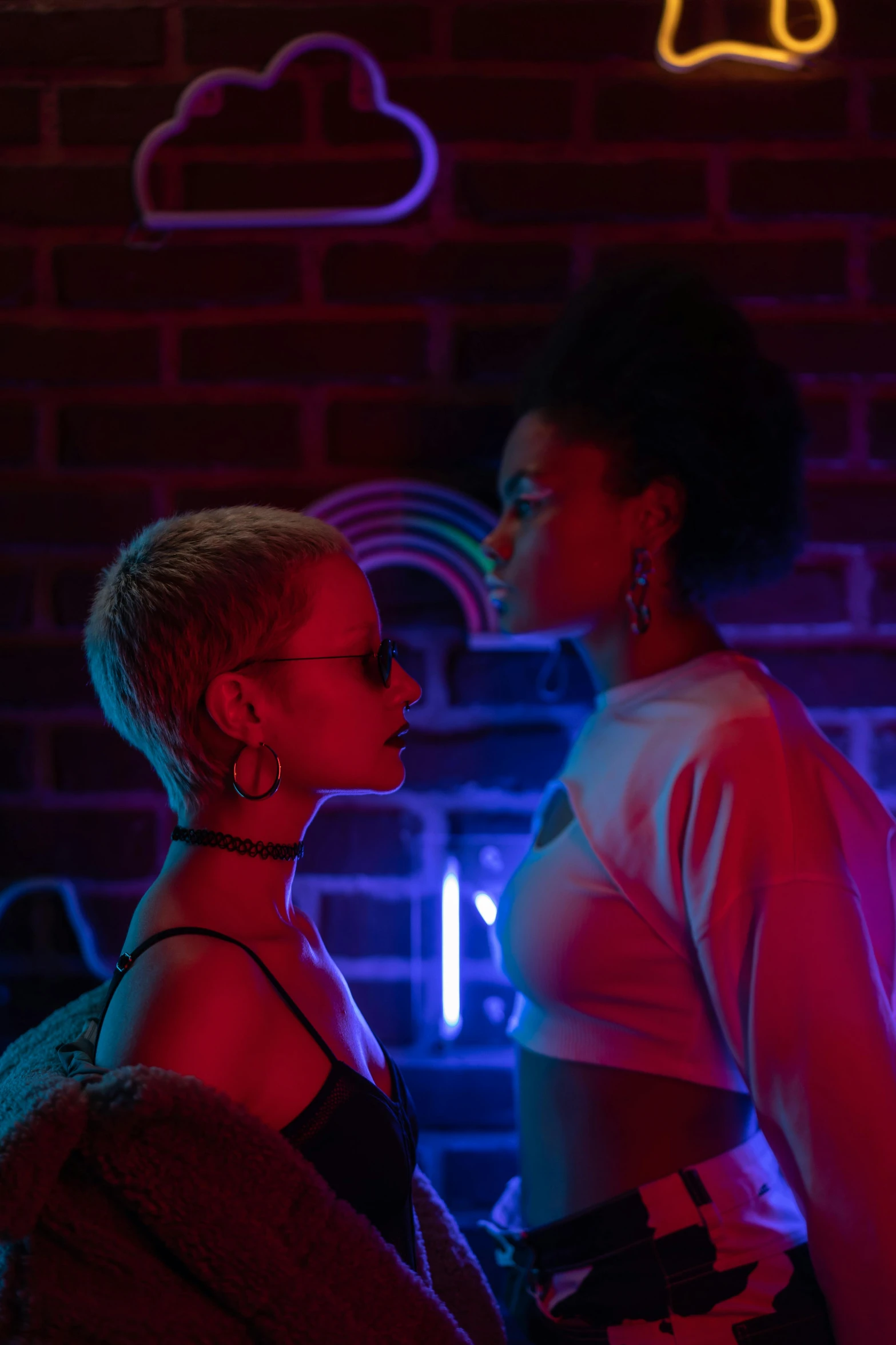 two women standing next to each other in front of neon signs, inspired by Nan Goldin, pexels, holography, willow smith zendaya, scene from fightclub movie, ( ( theatrical ) ), flirting