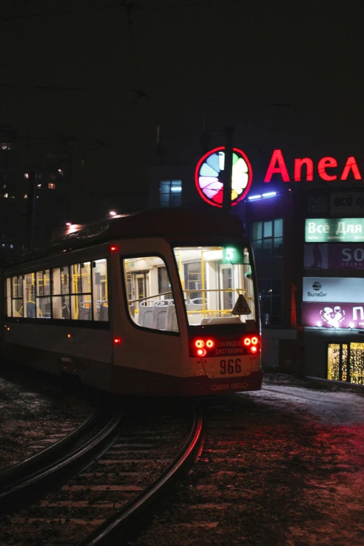 a train pulling into a train station at night, inspired by Alexander Deyneka, pexels contest winner, art nouveau, street tram, 2 5 6 x 2 5 6 pixels, norilsk, (3 are winter