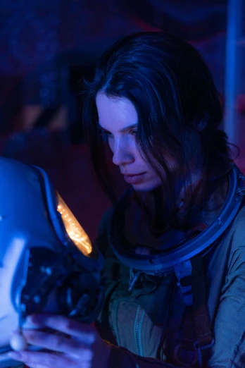 a woman in a space suit looking at a laptop, portrait anya taylor-joy, atmospheric cool color - grade, looking serious, slide show