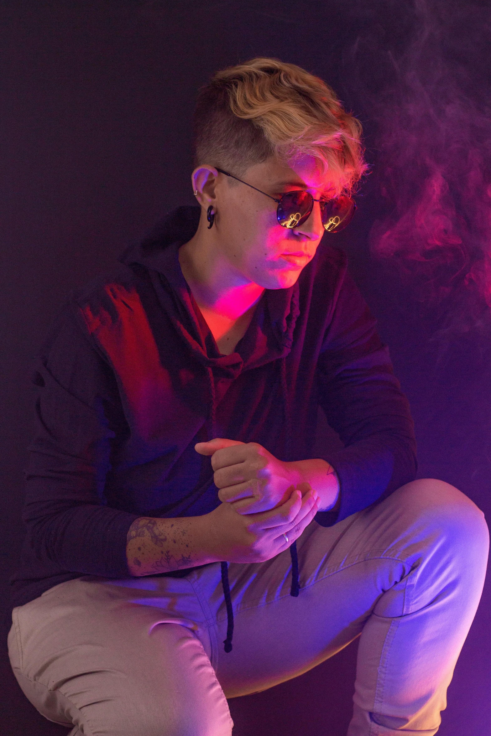 a man sitting on a stool with smoke coming out of his mouth, an album cover, inspired by Nikolaj Abraham Abildgaard, trending on pexels, wearing shades, lesbians, teenage boy, lights