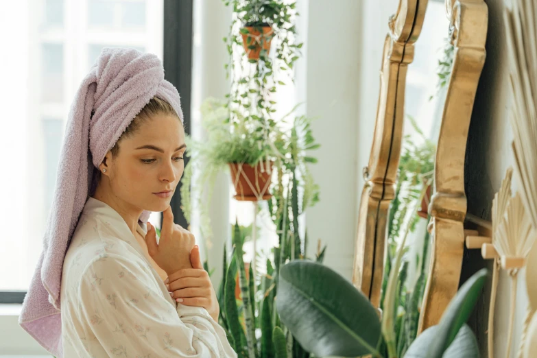 a woman with a towel wrapped around her head, by Emma Andijewska, trending on pexels, renaissance, next to a plant, looking in mirror, paradise garden massage, manuka