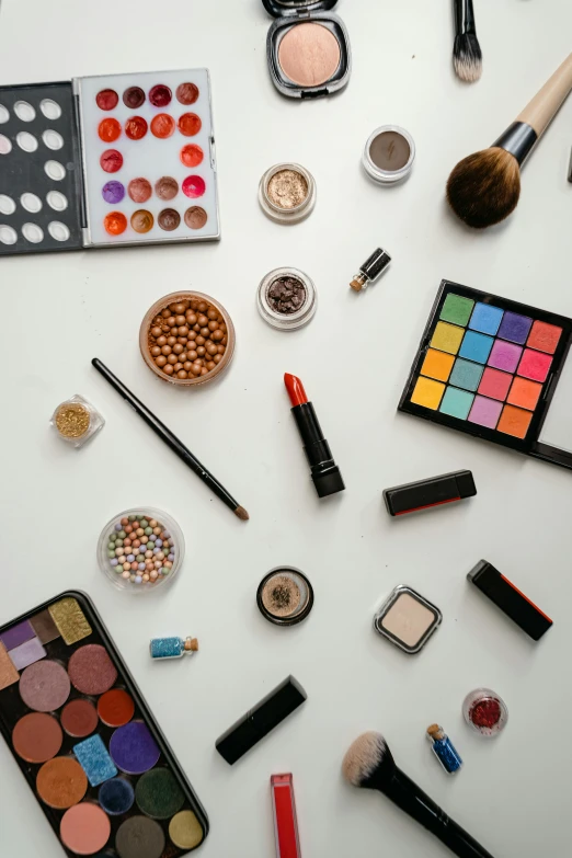 a table topped with lots of different types of makeup, a cartoon, trending on pexels, product studio lighting, thumbnail, multicoloured, white background