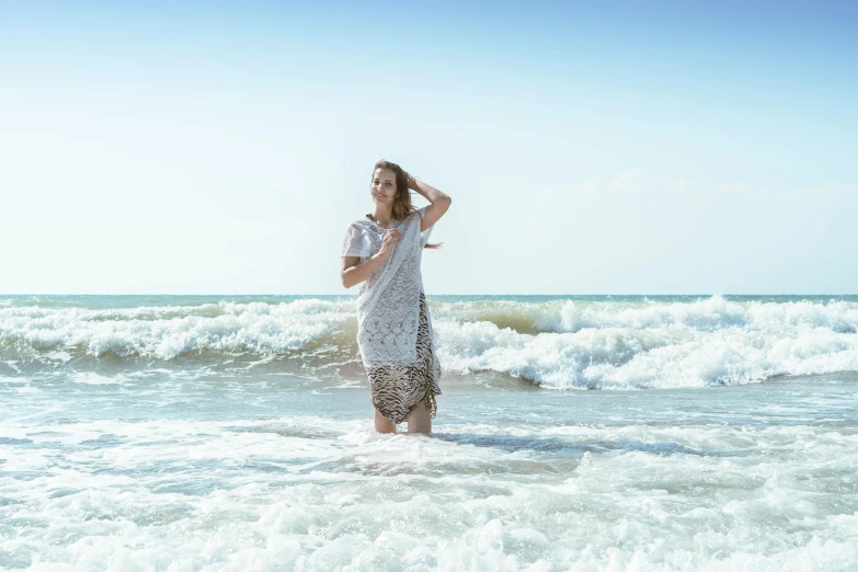 a woman standing on top of a beach next to the ocean, wearing a dress made of water, white water, profile image, having fun