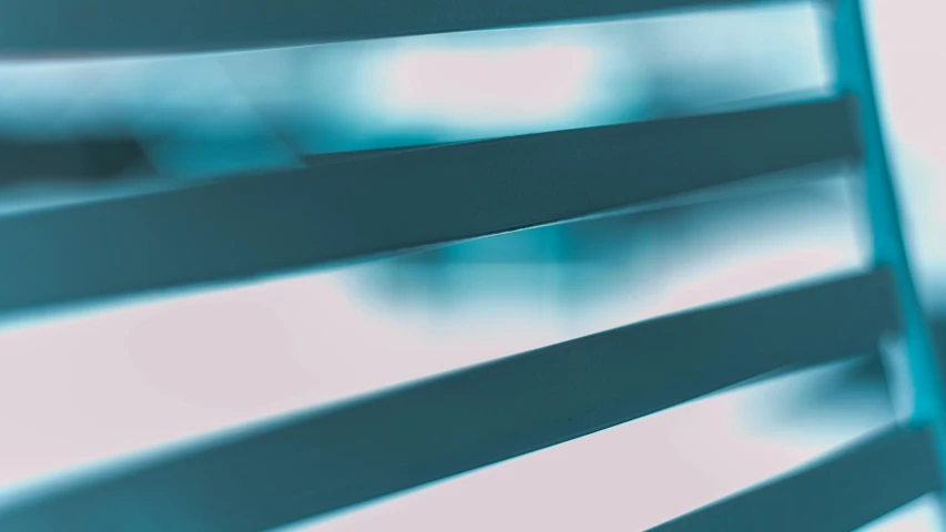 a close up of a chair with a blurry background, a raytraced image, by Julian Allen, unsplash, soft light through blinds, neon blue color, abstract illustration, teal tones