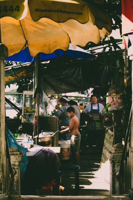 a group of people standing around a food stand, shady alleys, bangkok, taken on a 2000s camera, merchant tents