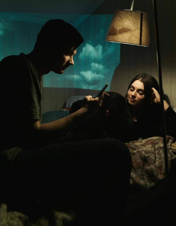 a man sitting on top of a bed next to a woman, inspired by Elsa Bleda, pexels contest winner, in a movie still cinematic, phone photo, charli bowater and artgeem, sci-fi movie still