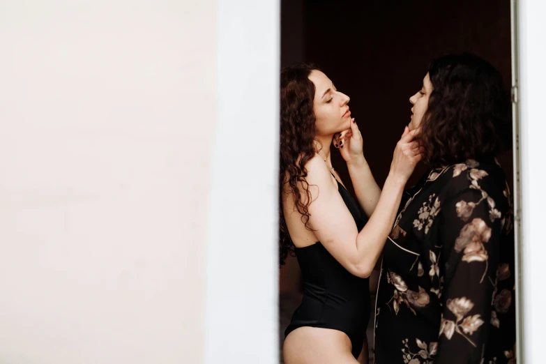 a couple of women standing next to each other, a photo, by Emma Andijewska, unsplash, renaissance, wearing a black bodysuit, making out, brunette, tall and slim figured