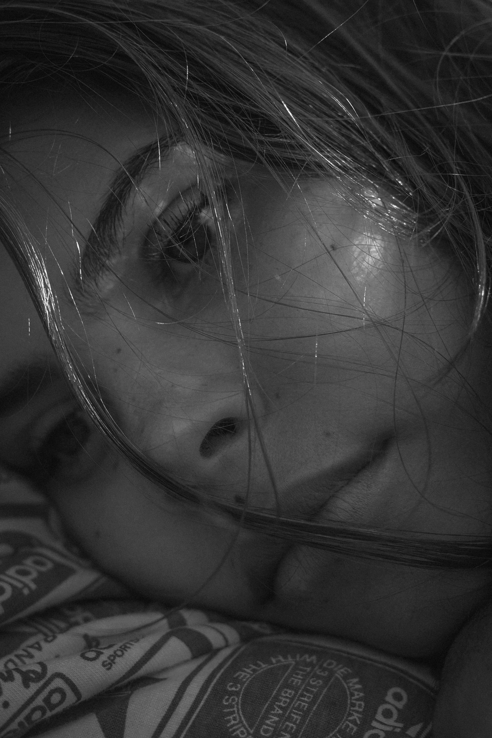 a close up of a person laying on a bed, a black and white photo, inspired by Roy DeCarava, tumblr, photorealism, billie eilish, ███beautiful face███, beautiful lonely girl, night time