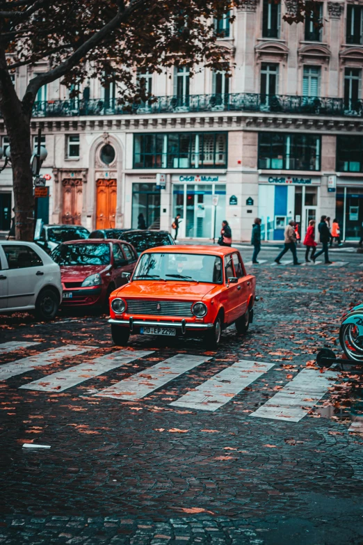 a red car parked on the side of a street, a photo, pexels contest winner, renaissance, crosswalks, lada, paris, fall season