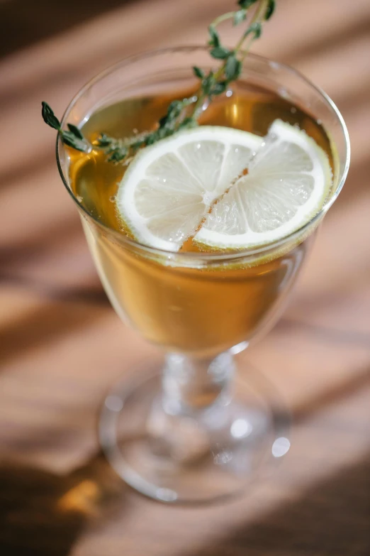 a cocktail sitting on top of a wooden table, tea, thumbnail, upclose, f/2.5