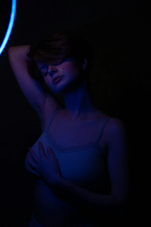 a woman standing in front of a blue light, inspired by Elsa Bleda, holography, young sensual woman, 5 0 0 px models, neon noir, medium portrait top light