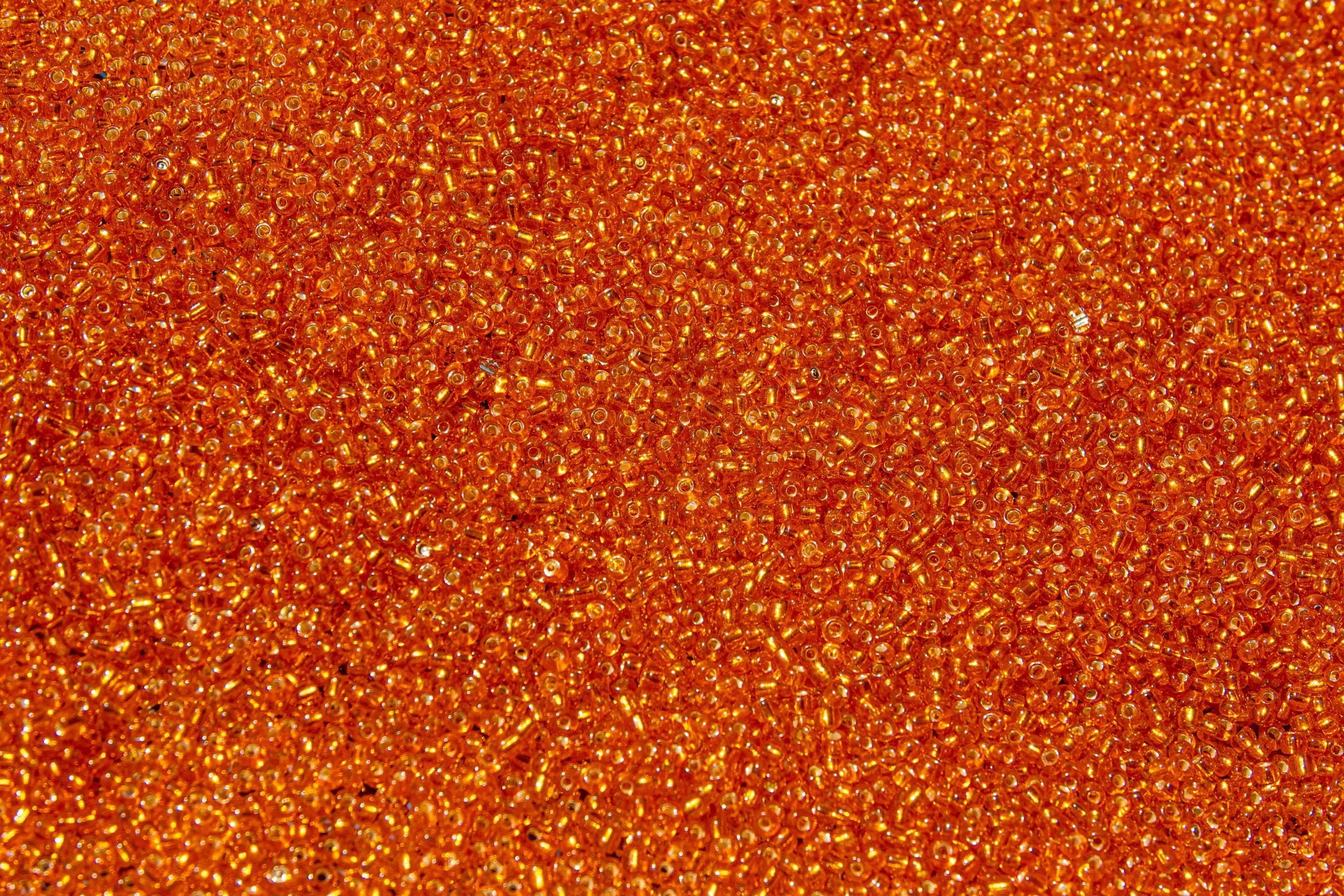 a close up of an orange glitter background, by Aurél Bernáth, glass beads, heavy grain high quality, crystal desert, vtm