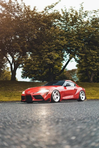 a red sports car parked on the side of the road, unsplash contest winner, hyperrealism, toyota supra, ✨🕌🌙, curvy build, samurai vinyl wrap