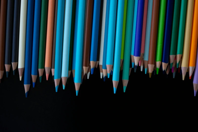 a row of colored pencils against a black background, a digital rendering, unsplash, blue colored, two colors, dezeen, seen from below