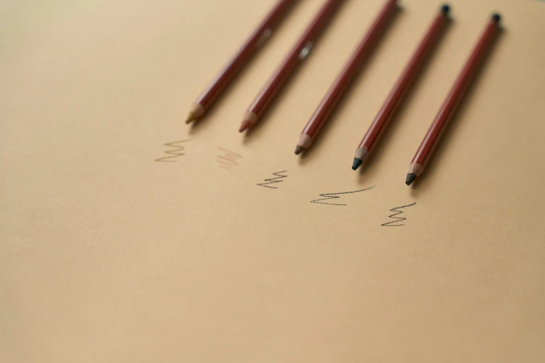a group of pencils sitting on top of a piece of paper, a drawing, trending on pexels, process art, black fine lines on warm brown, red and brown color scheme, thumbnail, minimal shading
