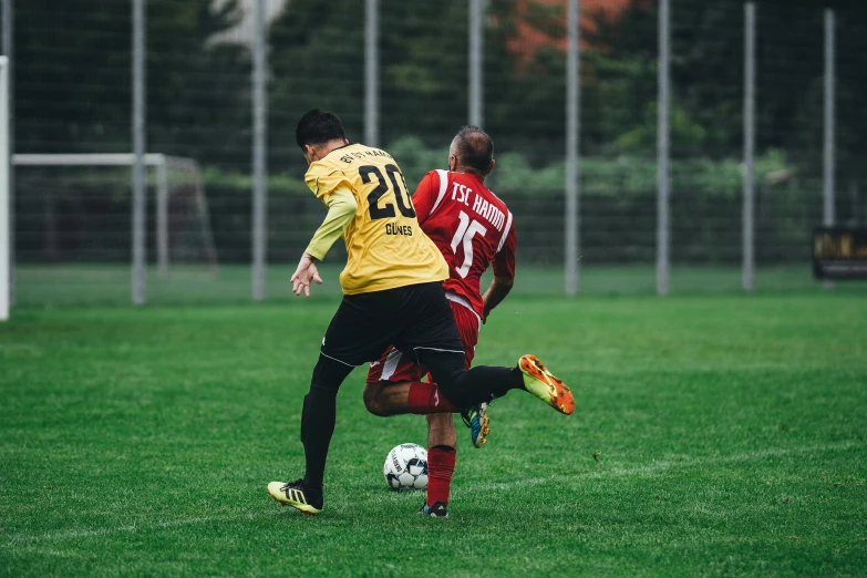 a couple of men playing a game of soccer, by Sebastian Spreng, pexels contest winner, yellows and reddish black, 4k footage, square, low quality photo