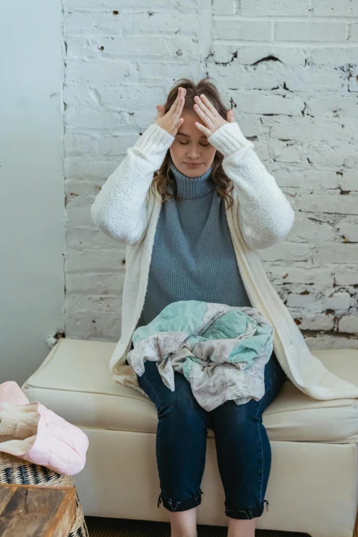 a woman sitting on top of a couch covered in blankets, happening, woman crying, maternity feeling, headspace, deteriorated