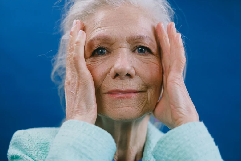 an older woman holding her hands to her face, an album cover, by Jan Rustem, unsplash, hyperrealism, blue, neuroscience, still from film, looking happy