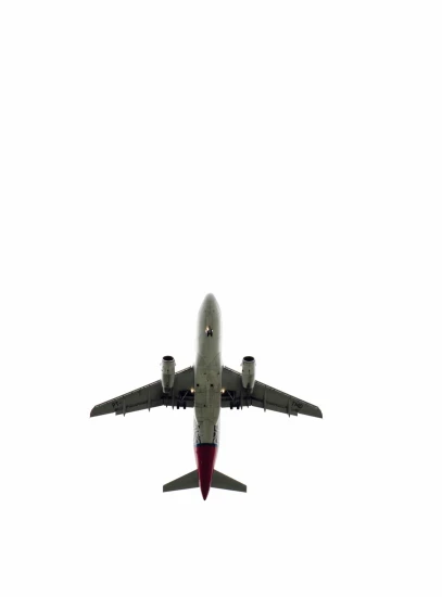a large jetliner flying through a white sky, by Brian Alfred, minimalism, hegre, gif, drone photograpghy, wine-red and grey trim
