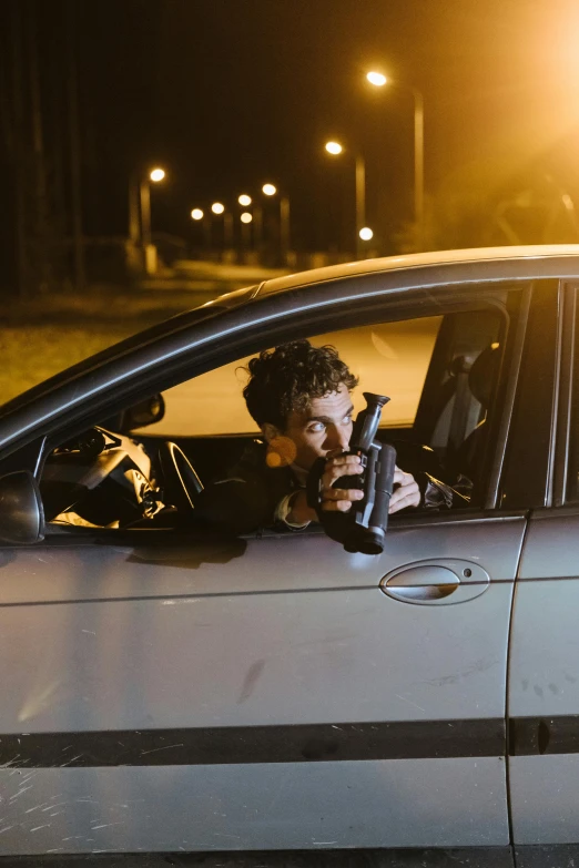 a man sitting in a car with a gun in his hand, robert sheehan, high speed chase, in the spotlight, 2 1 savage