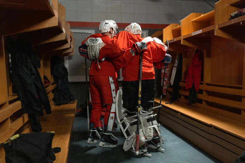 a group of men standing next to each other in a locker, by Meredith Dillman, pexels contest winner, full ice hockey goalie gear, red uniform, long shot from back, hugging each other