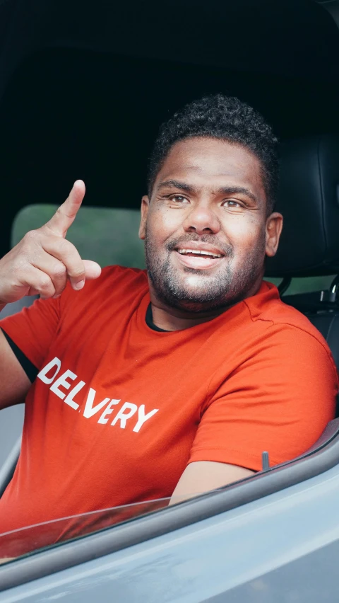 a man sitting in a car giving a thumbs up, inspired by Paul Georges, pexels contest winner, hurufiyya, manly face, mkbhd, beefy, round-cropped