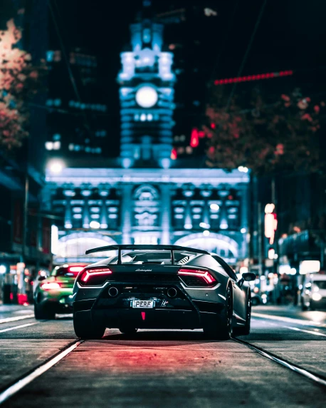 a car driving down a city street at night, an album cover, by Sebastian Vrancx, pexels contest winner, lamborghini, melbourne, thumbnail, tourist photo