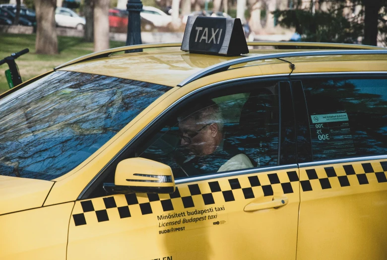 a man sitting in the driver's seat of a taxi, a photo, square, white and yellow scheme, thumbnail