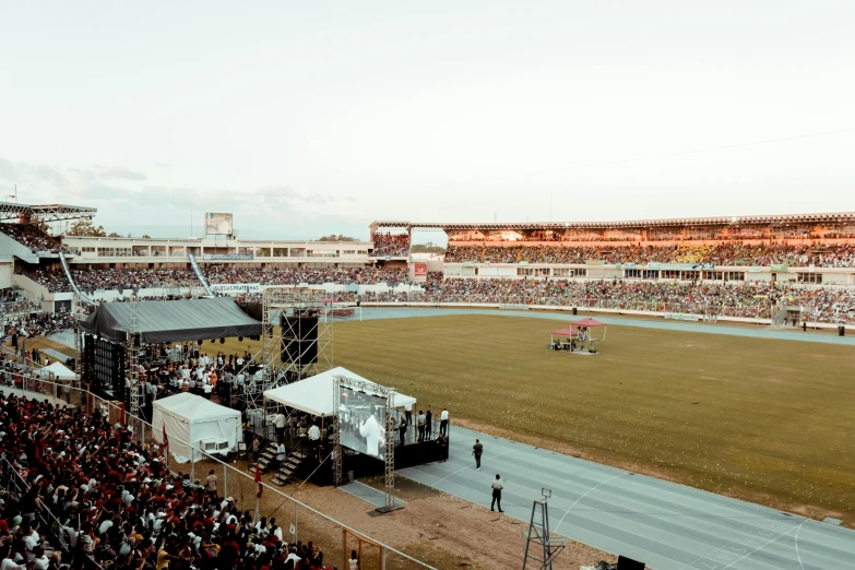a large stadium filled with lots of people, by Lee Loughridge, pexels contest winner, happening, at racer track, jamaica, magic hour, formula 1