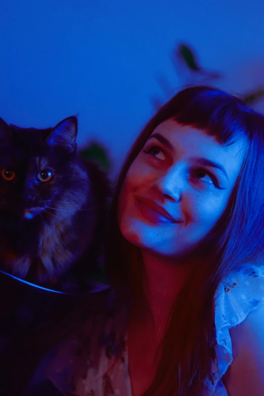 a woman holding a cat in her arms, an album cover, by Julia Pishtar, trending on reddit, blue lights and purple lights, close-up portrait film still, medium shot of two characters, high quality photo