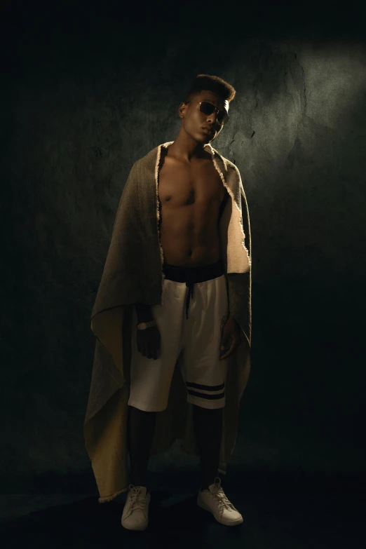 a shirtless man standing in a dark room, an album cover, trending on pexels, renaissance, covered with blanket, black teenage boy, boxer, at a fashion shoot