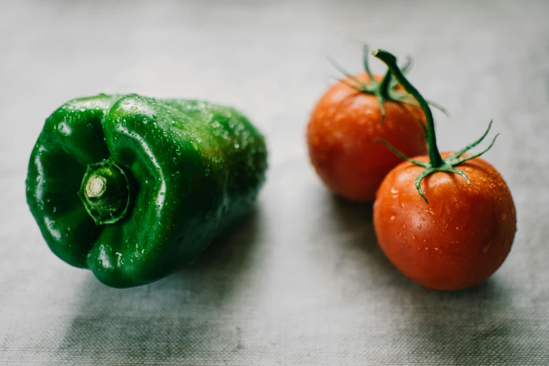 two tomatoes and a green pepper on a table, unsplash, fan favorite, background image, mexican, battered