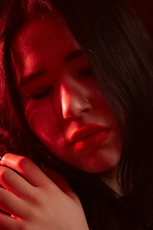 a close up of a person holding a cell phone, an album cover, inspired by Elsa Bleda, realism, beautiful asian woman, darkness aura red light, pensive, bright red