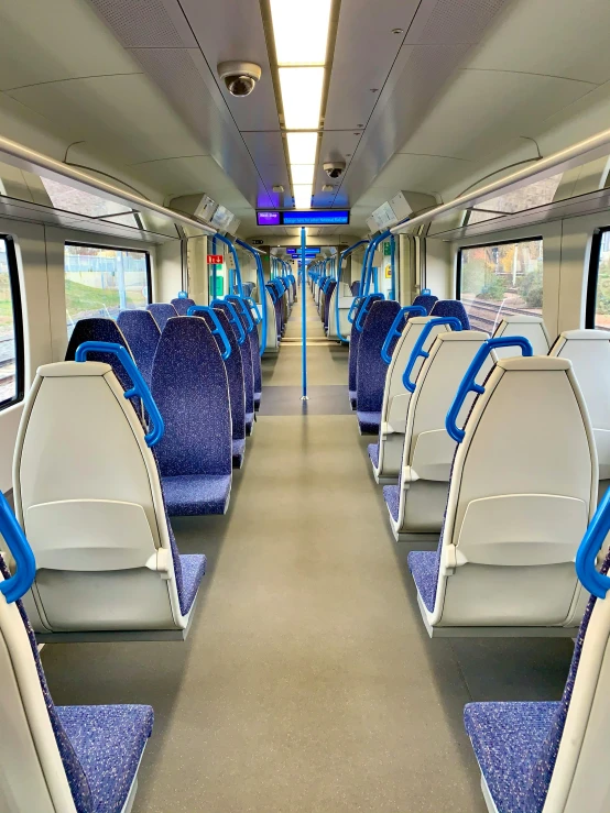 the inside of a train with blue seats, photograph taken in 2 0 2 0, thumbnail, low quality photo, standing straight