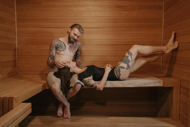 a man and a woman sitting in a sauna, a tattoo, unsplash, straya, pinup body, full length photo, bench