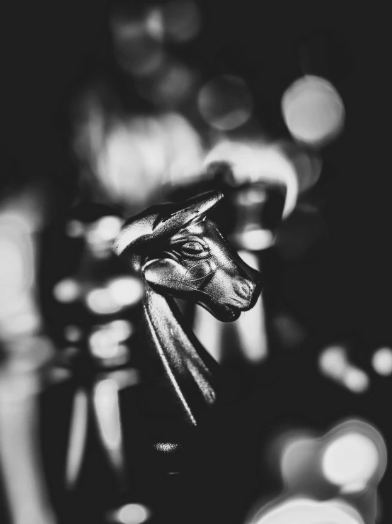 a black and white photo of a horse statue, a statue, by Daniel Gelon, art photography, deep bokeh, cinematic. by leng jun, sleek metal head