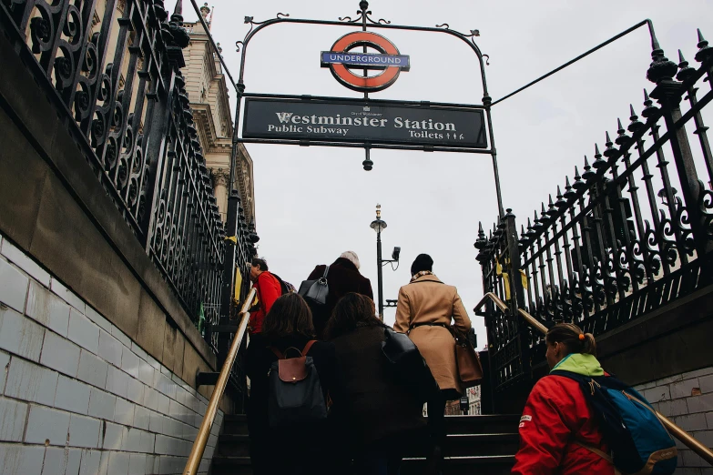 a group of people walking up a set of stairs, by Nina Hamnett, pexels, london underground tube station, a cozy, 🚿🗝📝, underwater westminster