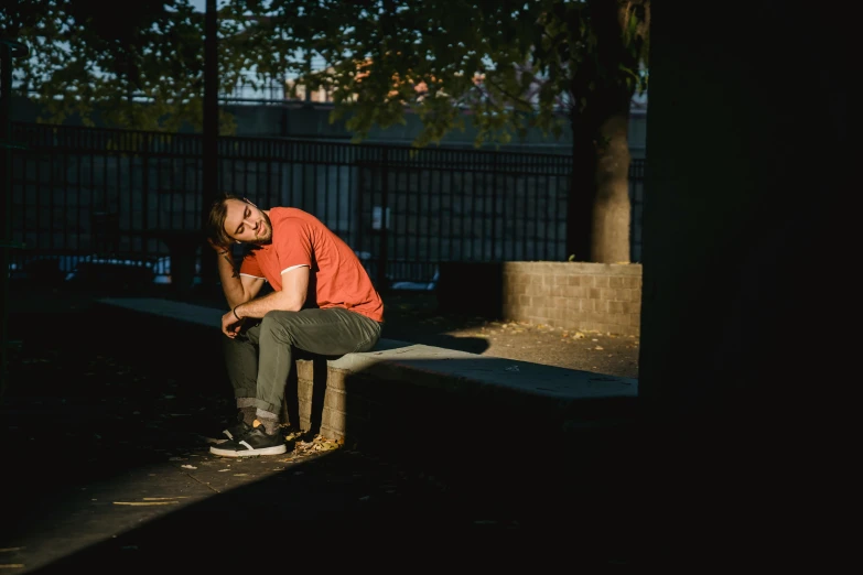 a man sitting on top of a cement bench, inspired by Elsa Bleda, pexels contest winner, happening, the last portrait of mac miller, warm lighting with cool shadows, lachlan bailey, 15081959 21121991 01012000 4k