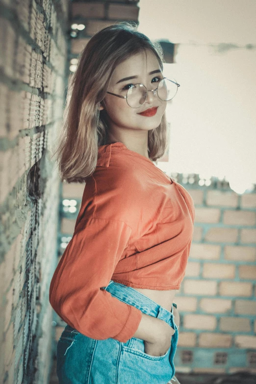 a woman wearing glasses leaning against a brick wall, inspired by Elsa Bleda, pexels contest winner, wearing a cropped top, gray and orange colours, ruan cute vtuber, red clothes