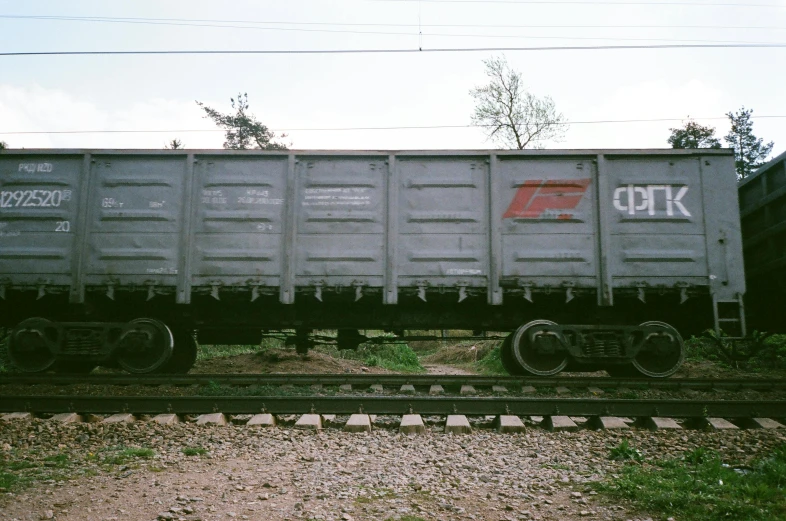 a train car with graffiti on the side of it, by Attila Meszlenyi, unsplash, graffiti, photo taken on fujifilm superia, 2000s photo, grey metal body, mine cart