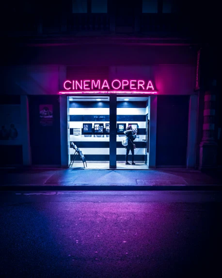 a building with a neon sign that says cinema opera, inspired by Elsa Bleda, unsplash contest winner, alessio albi, storefront, purple scene lighting, cinematic outfit photo