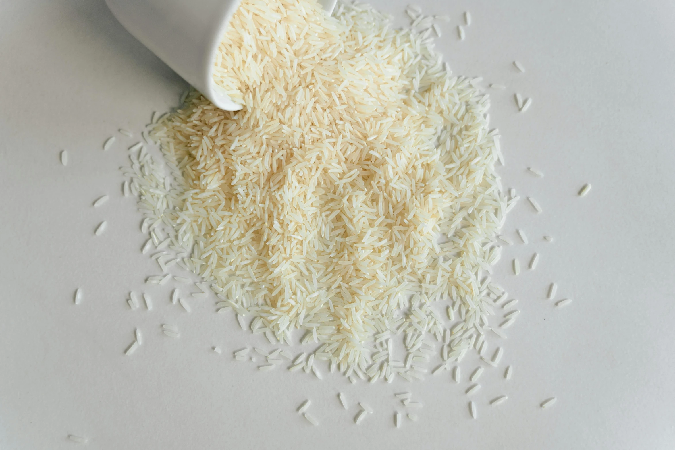 a white cup sitting on top of a pile of rice, detailed product image, shredded, eggshell color, pouring